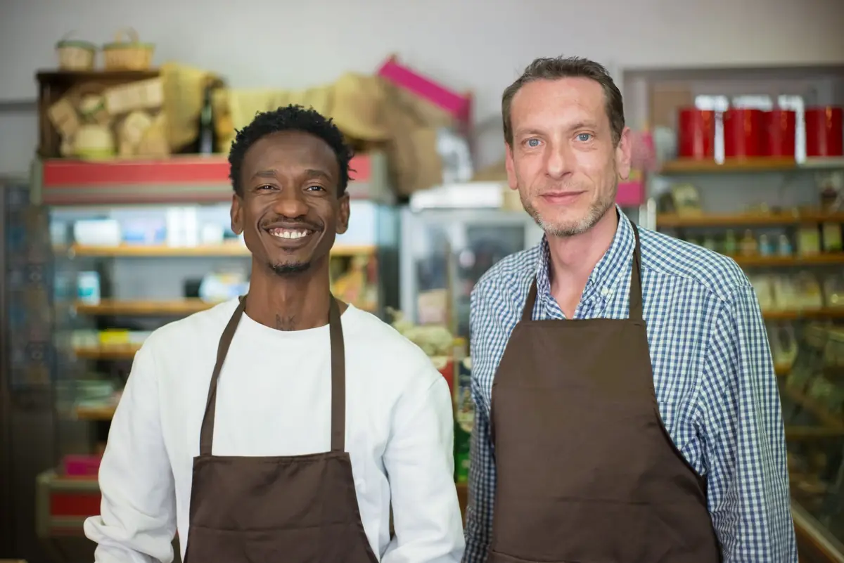 Dois funcionários de avental na mercearia